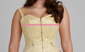 Woman wearing a corset with a line showing where to measure the bust size