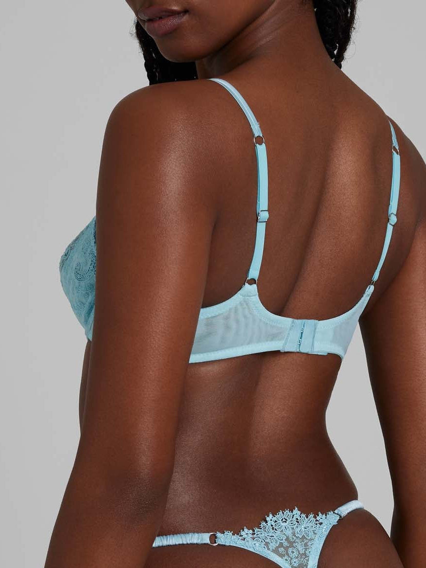 Women wearing blue lace bra and thong with white bows from behind