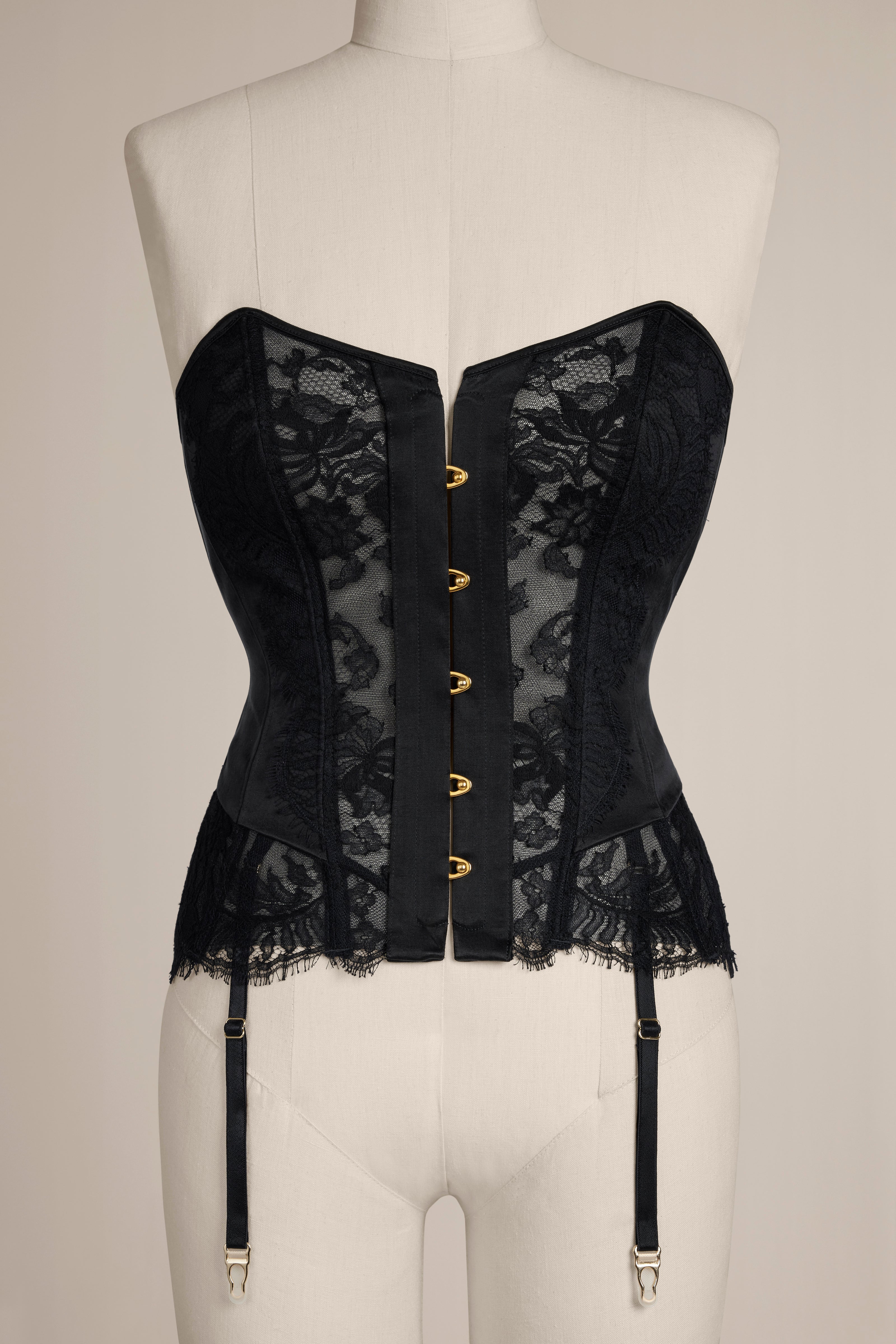 Black lace corset on a mannequin against a neutral background
