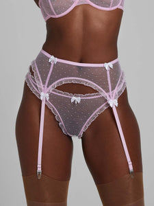 Close-up of woman wearing bubble-gum pink lace lingerie set with bra, thong and suspenders