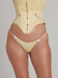 Close-up of woman wearing yellow thong with white bows